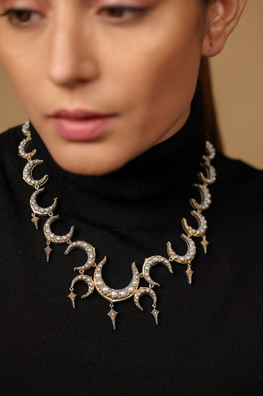 Close-up of the crescent silhouette and black enamel detailing on the Ragini Necklace