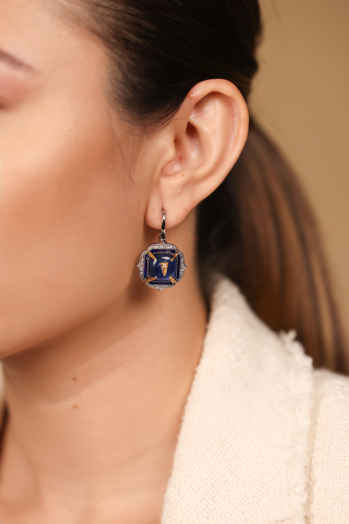 Angled view of Aurora Earrings showing the hand-painted blue enamel finish and 18K gold detailing