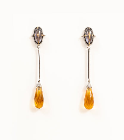 Meeti Earrings with an amethyst stud, gold star motif, long silver bar, and faceted topaz briolette drop
