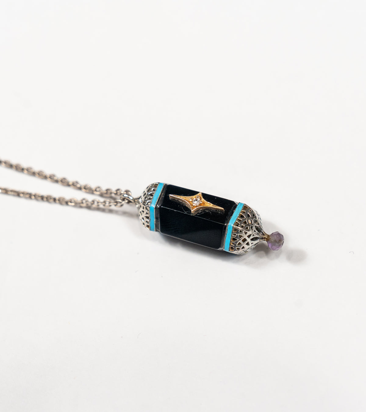 Detail of the hand-painted turquoise enamel accent on the Sirius Pendant